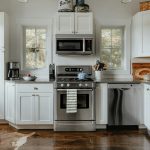 a kitchen with white cabinets and stainless steel appliances