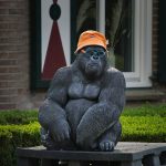 A gorilla statue wears a hat and sunglasses